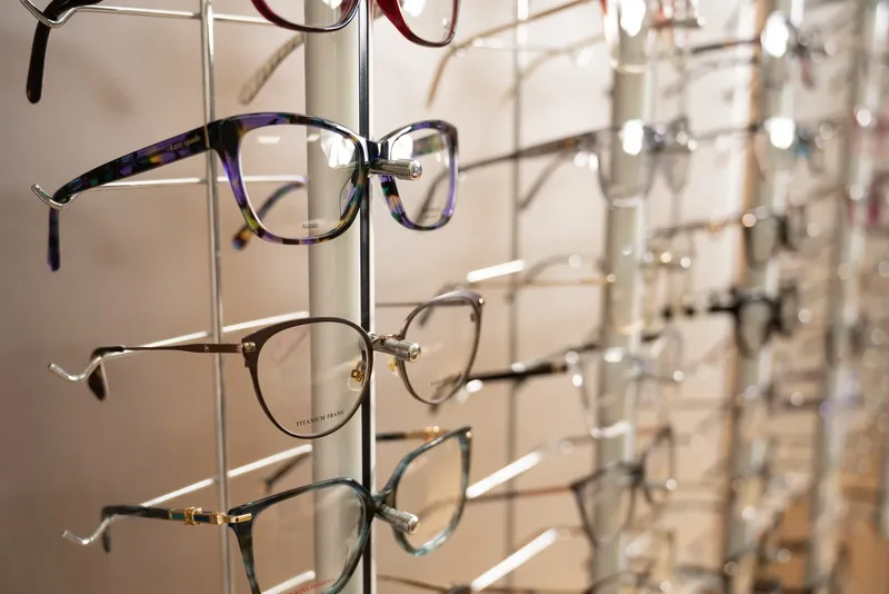 A patterned purple Kate Spade frame on the eyeglasses wall rack