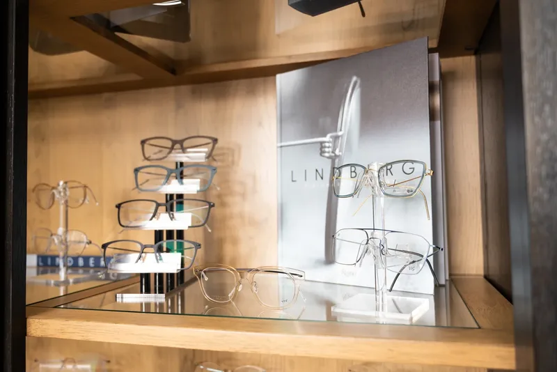 Lindberg titanium frames on risers beside a Lindberg lookbook in the display cabinet