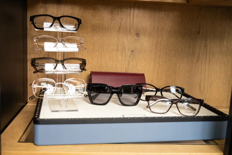 Saint Laurent and Gucci frames arranged on a tray in the designer cabinet
