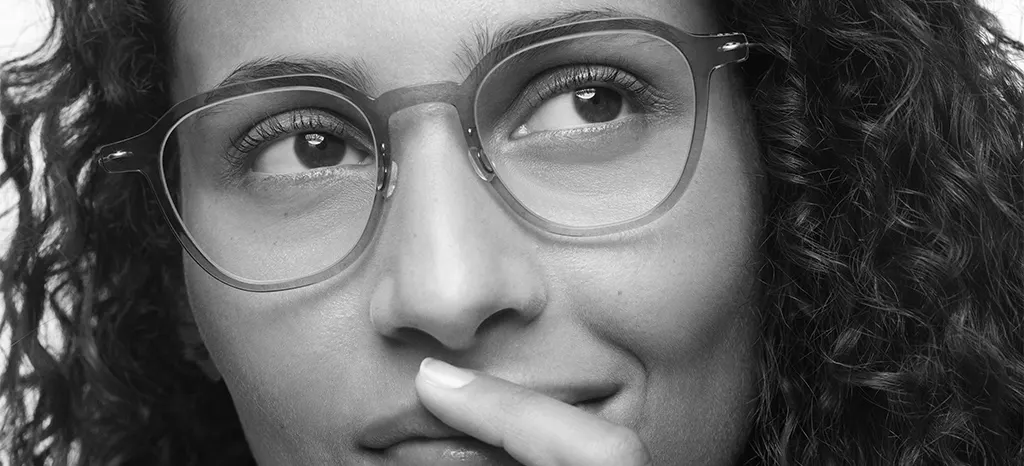 Black-and-white closeup of a woman with curly hair wearing Lindberg eyeglasses