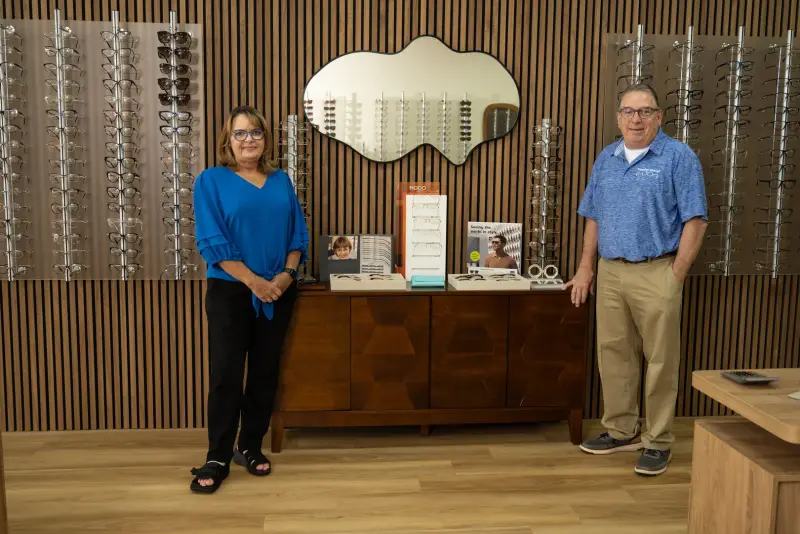 Two Kingsley Optical staff members standing in the showroom beside frame displays