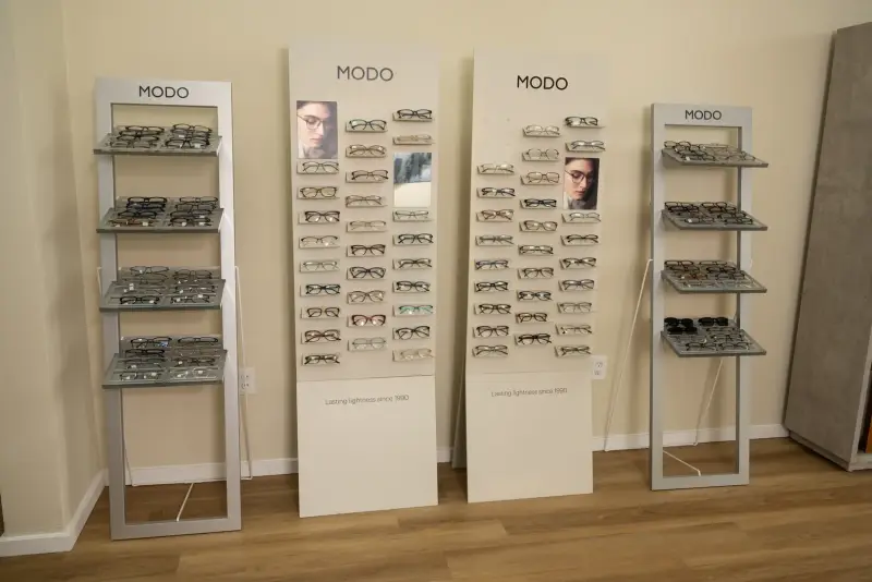 Four MODO floor display stands holding rows of eyeglass frames