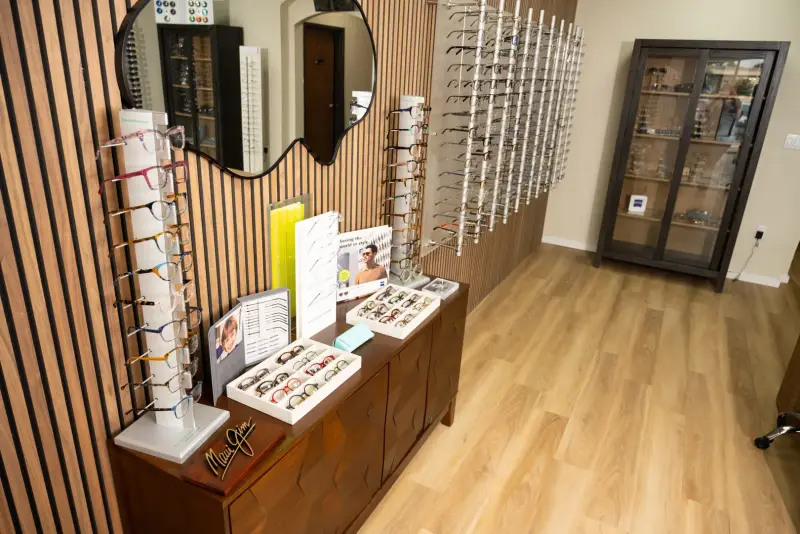 Wide view of the showroom with frame towers, a slatted wood wall, and a display cabinet